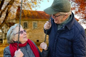 elderly man and woman in swing