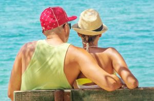 couple with hats by the sea