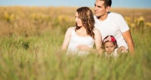 couple with kid in grass