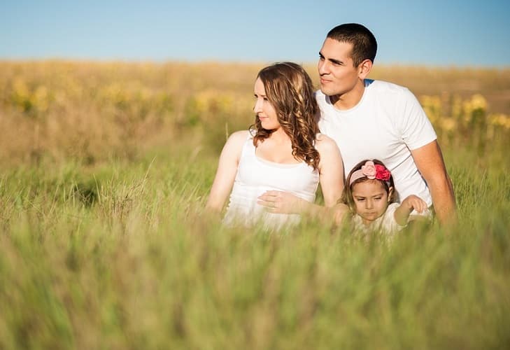 couple with kid in grass