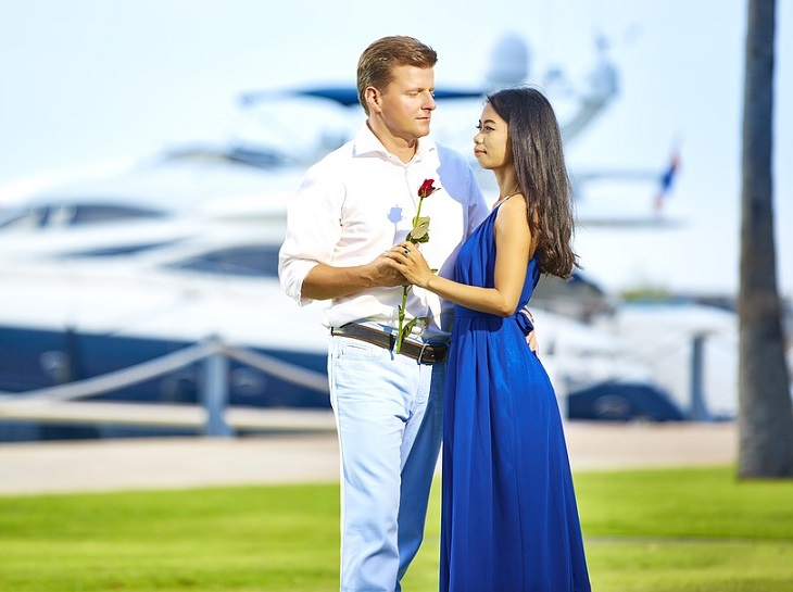 man presenting his woman with flower