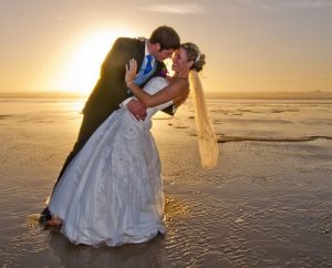 newly weds kissing at sunset