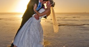 newly weds kissing at sunset