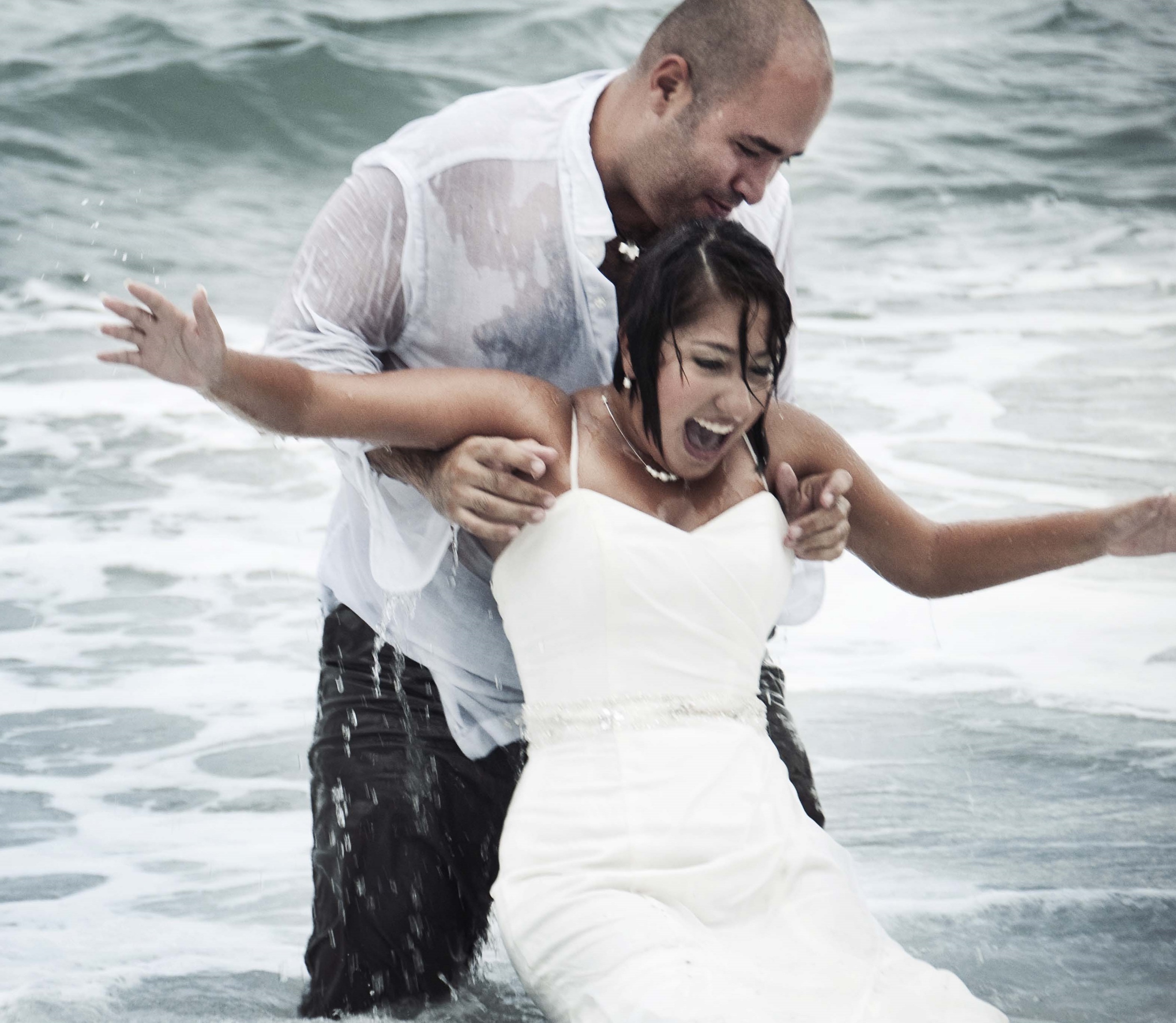 wedded couple having fun in water