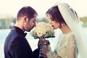 wedded couple smelling flowers