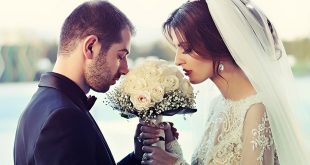 wedded couple smelling flowers