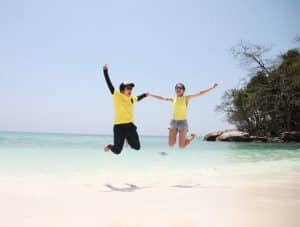 woman and man jumping while holding hands