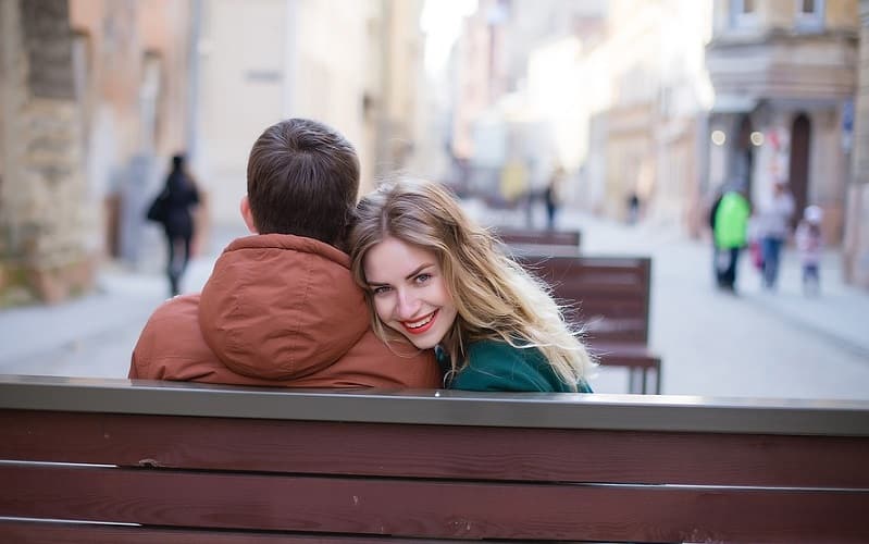 woman and man seating on bench